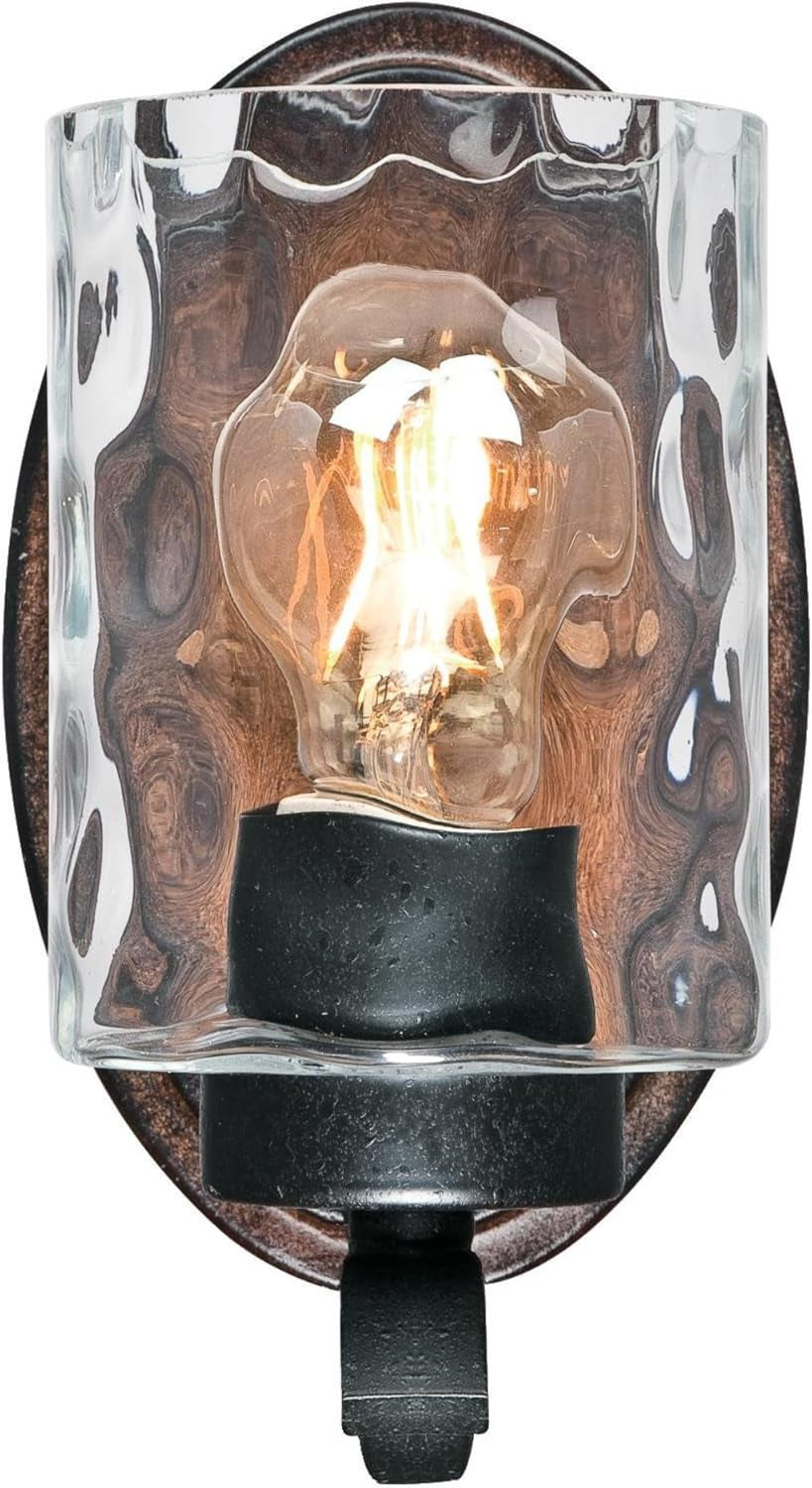 Front view of wall sconce showing clear hammered glass shade, lit bulb and wood-tone back plate