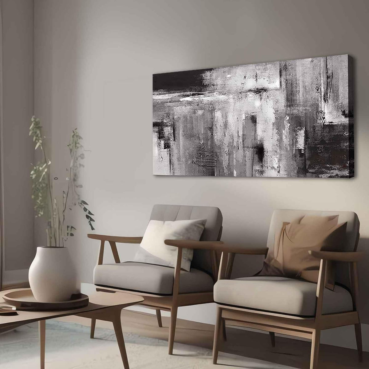 Abstract gray canvas hung above two mid-century armchairs with a round wood coffee table and tall vase