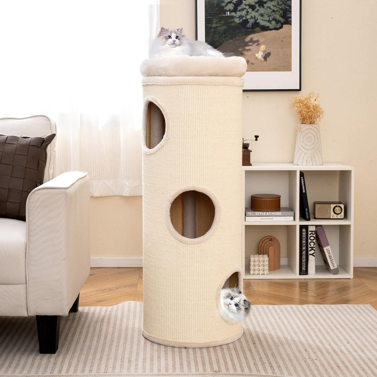 Beige 4-tier cat tower placed in a living room corner beside a couch and shelving in vertical tunnel configuration
