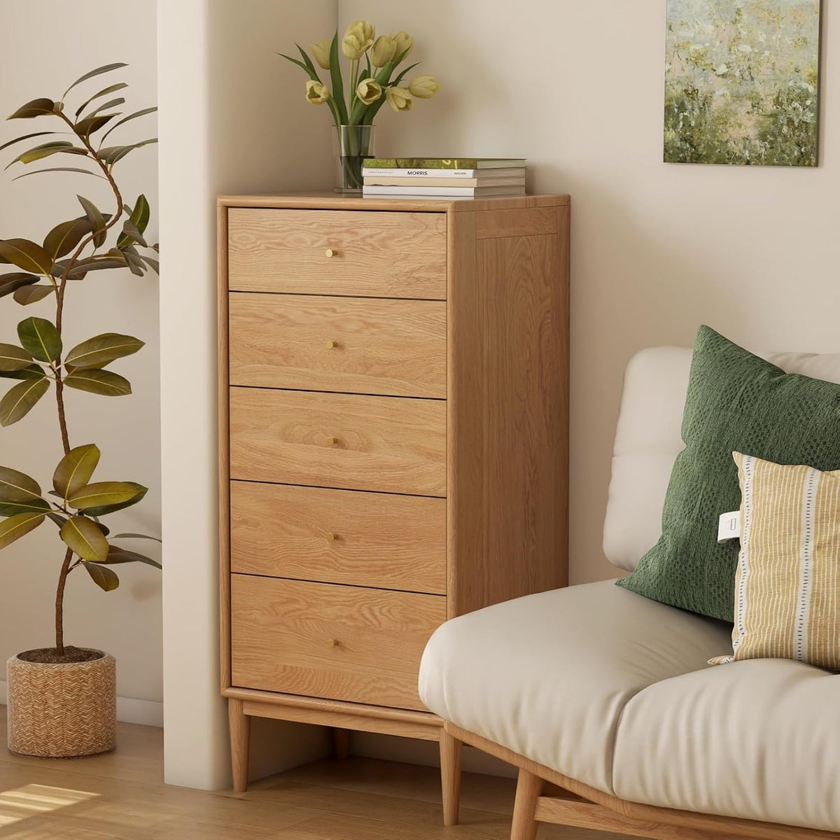 Oak tall chest tucked next to a sofa with green pillows and a potted plant in a cozy corner vignette.