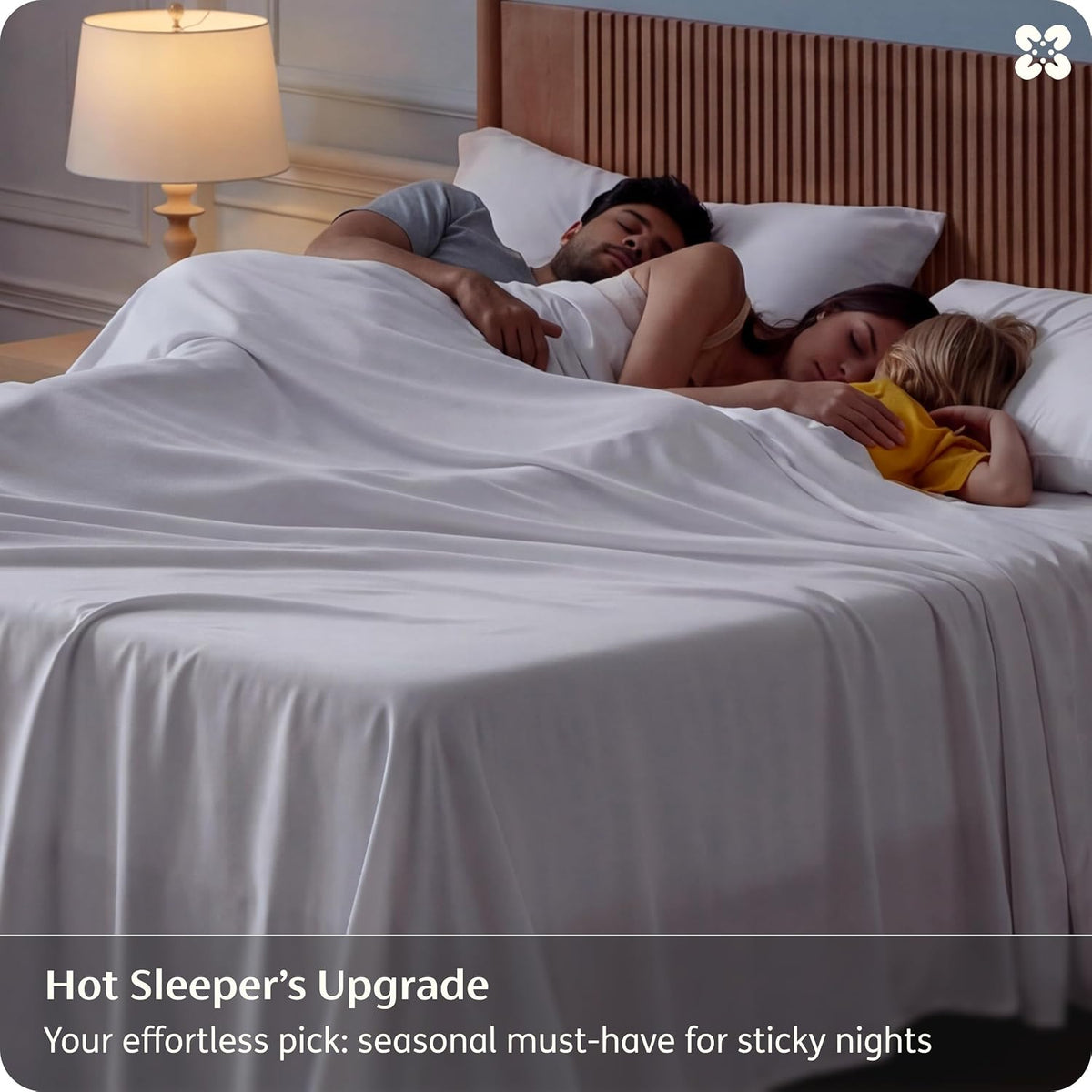 Two adults and a child resting under white sheets on a bed in a dimly lit bedroom scene