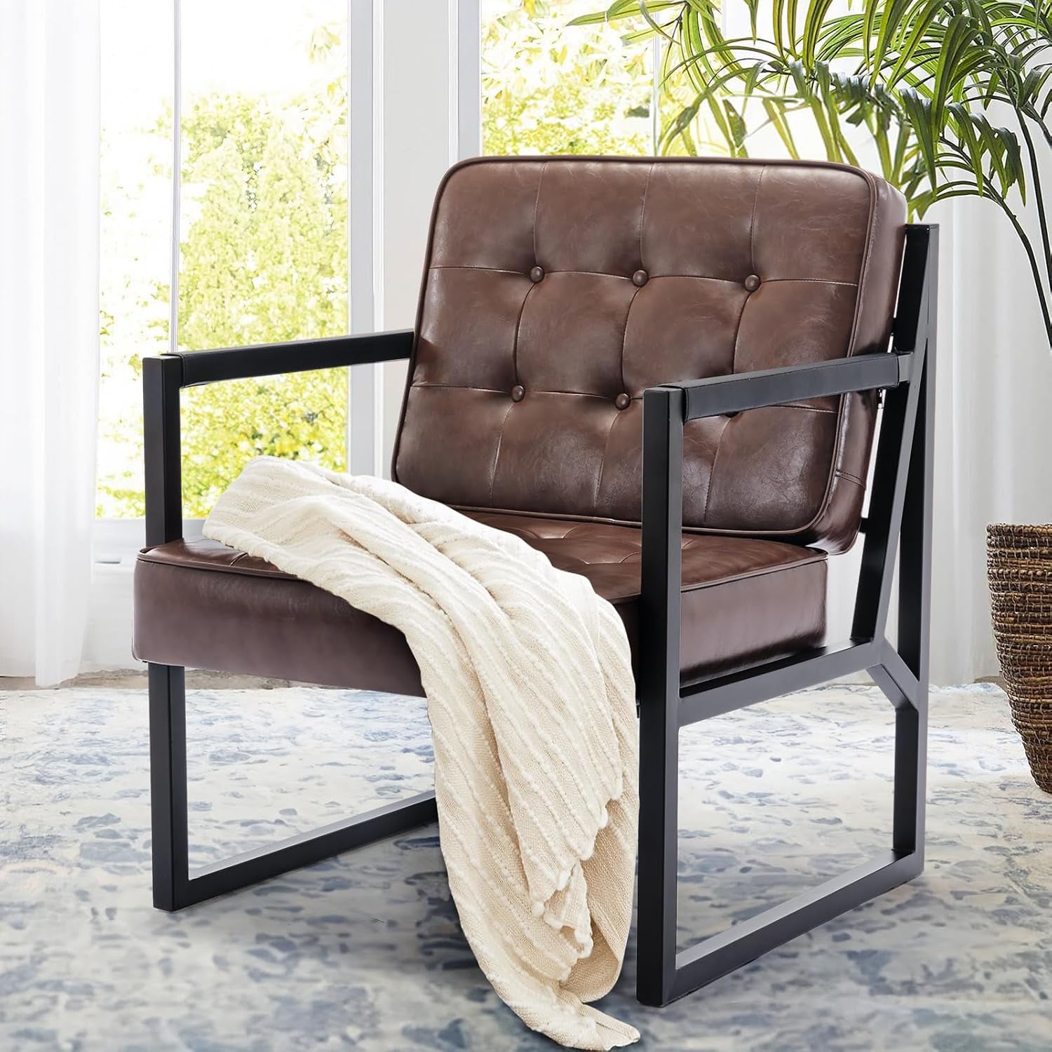 Lifestyle close-up — a single brown faux-leather chair with a throw draped over the seat by a window.