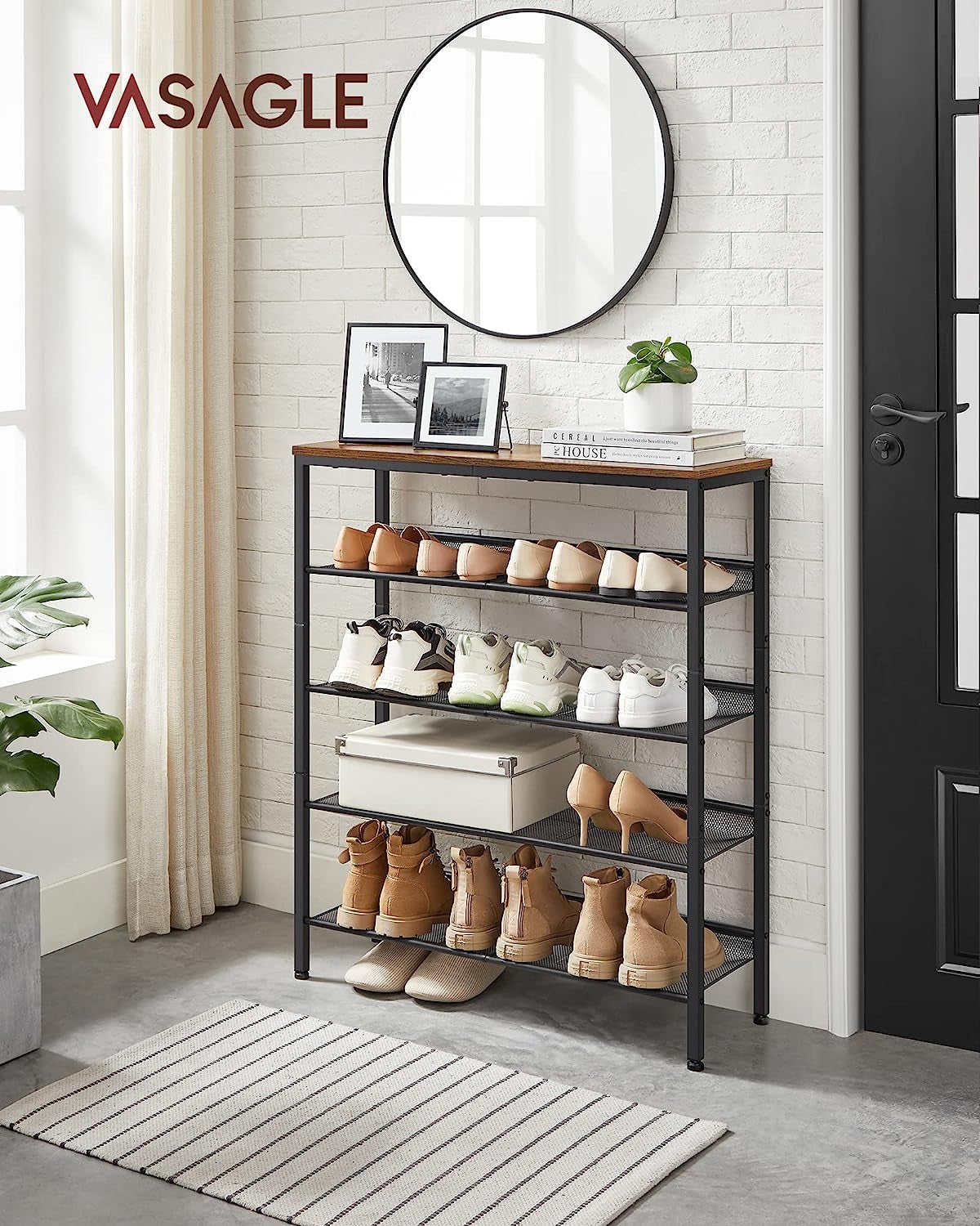 Five-tier shoe rack with rustic top and black frame displayed in an entryway under a round mirror with shoes on the shelves