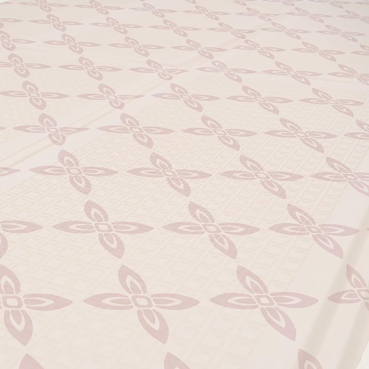 Close-up of the pale pink side with repeating floral-like motifs and subtle textured grid