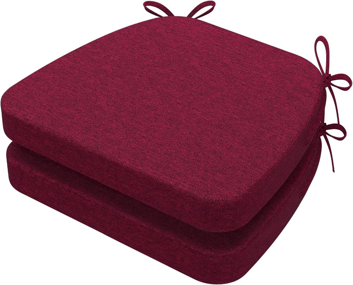 Angled side view of two wine-red D-shaped cushions stacked, showing rounded front and tied loops at the side.