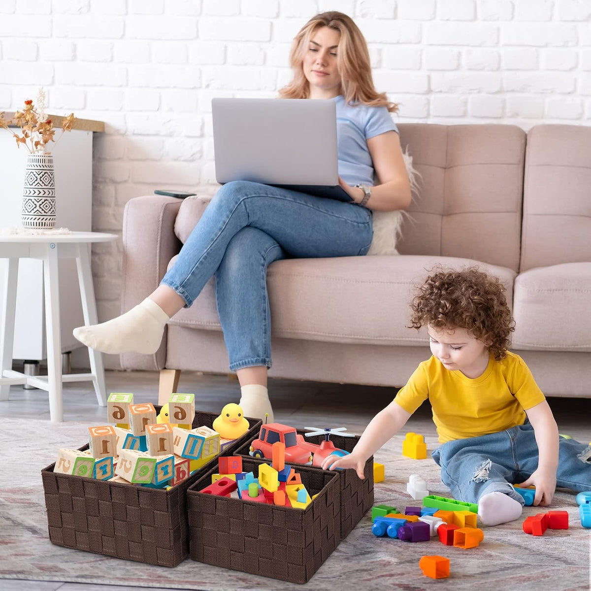 Living room scene with a child playing and three brown baskets filled with toys on the floor in foreground
