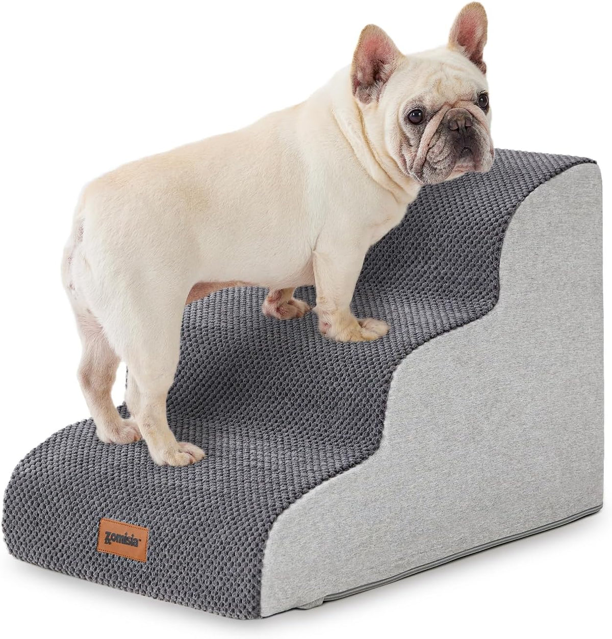 Side-angle view of a cream-colored French bulldog on gray three-step pet stairs with textured top and light gray side