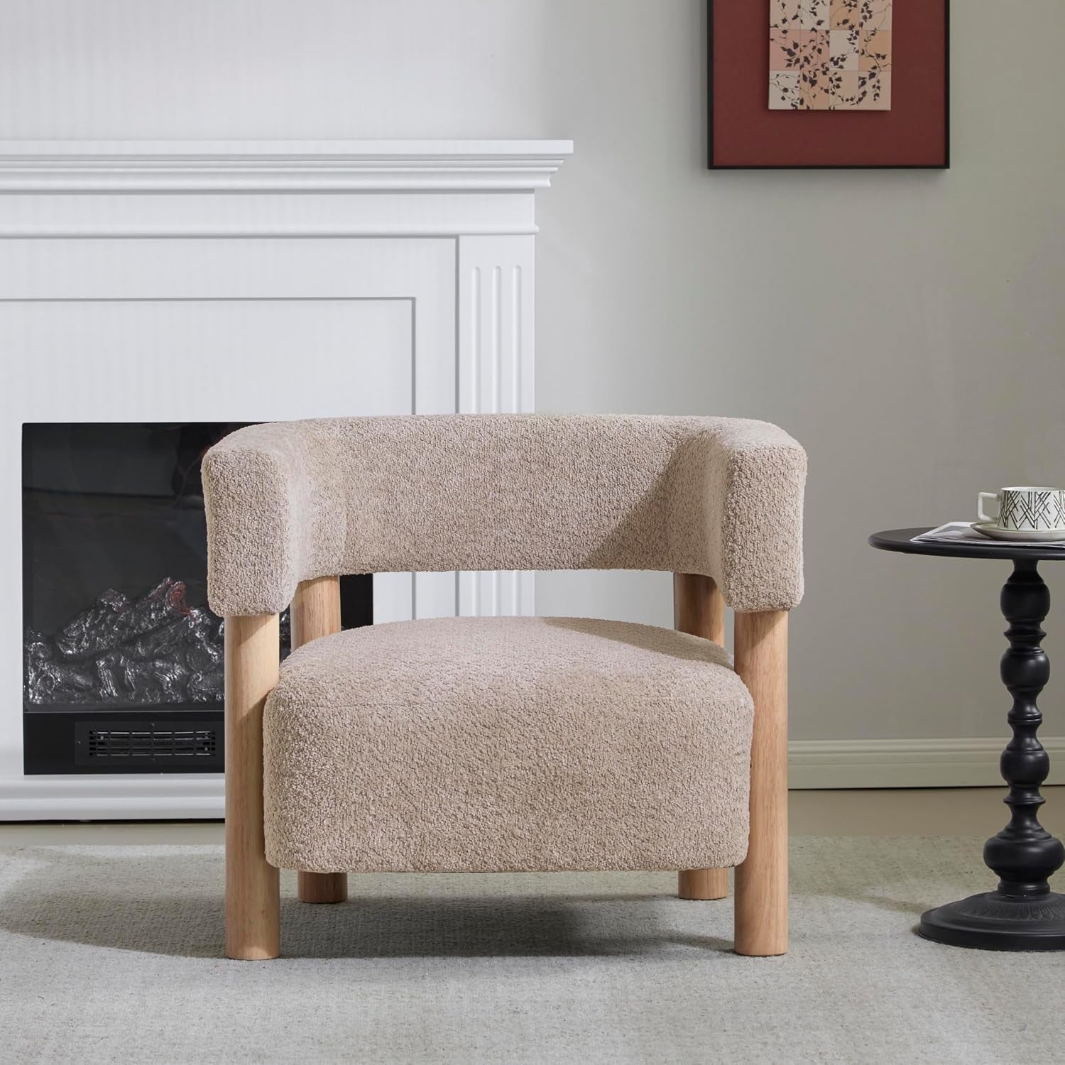 Light camel boucle low-profile accent chair with rounded back and natural wood legs in a neutral living room