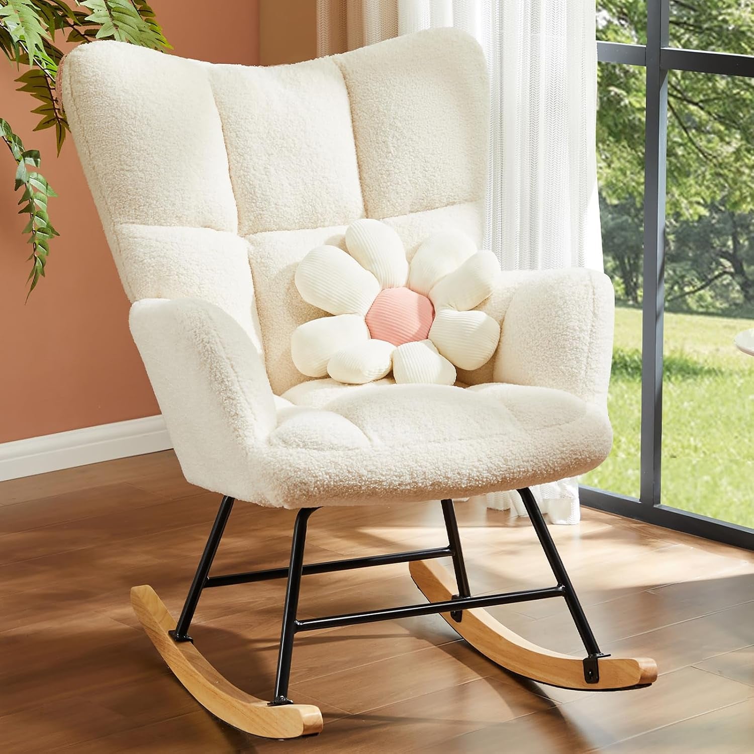 Cream-colored upholstered glider chair with tufted back and wooden rockers, shown with a flower cushion.