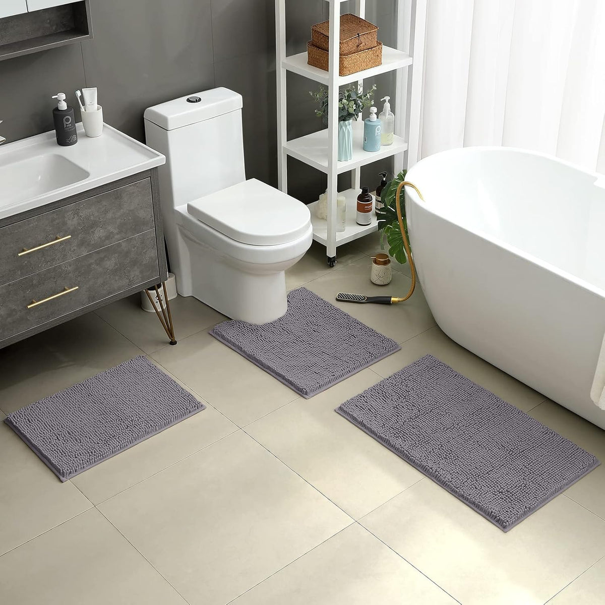 Grey chenille rugs staged in a modern bathroom around the toilet and bathtub, floor-level perspective