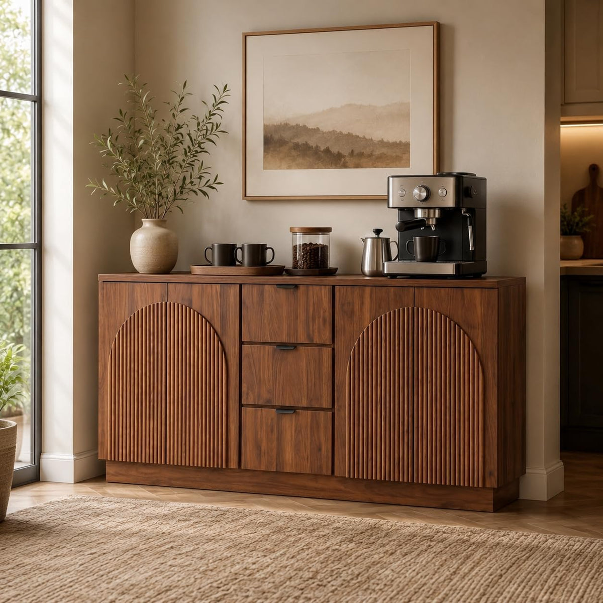 Walnut cabinet topped with coffee maker, mugs, and decorative vase beneath framed art.