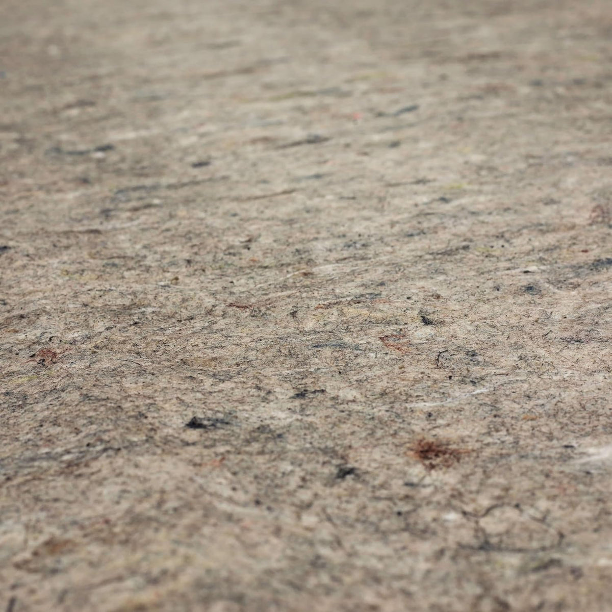 Close-up view of mottled felt cushion surface with multicolored recycled fibers visible.