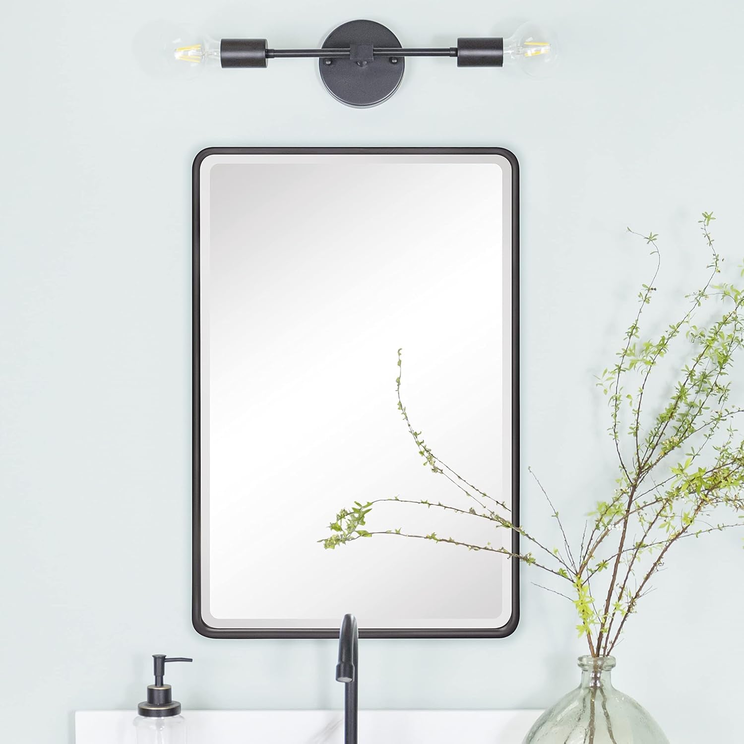 Matt black beveled mirror medicine cabinet mounted above sink, front view in a styled bathroom setting