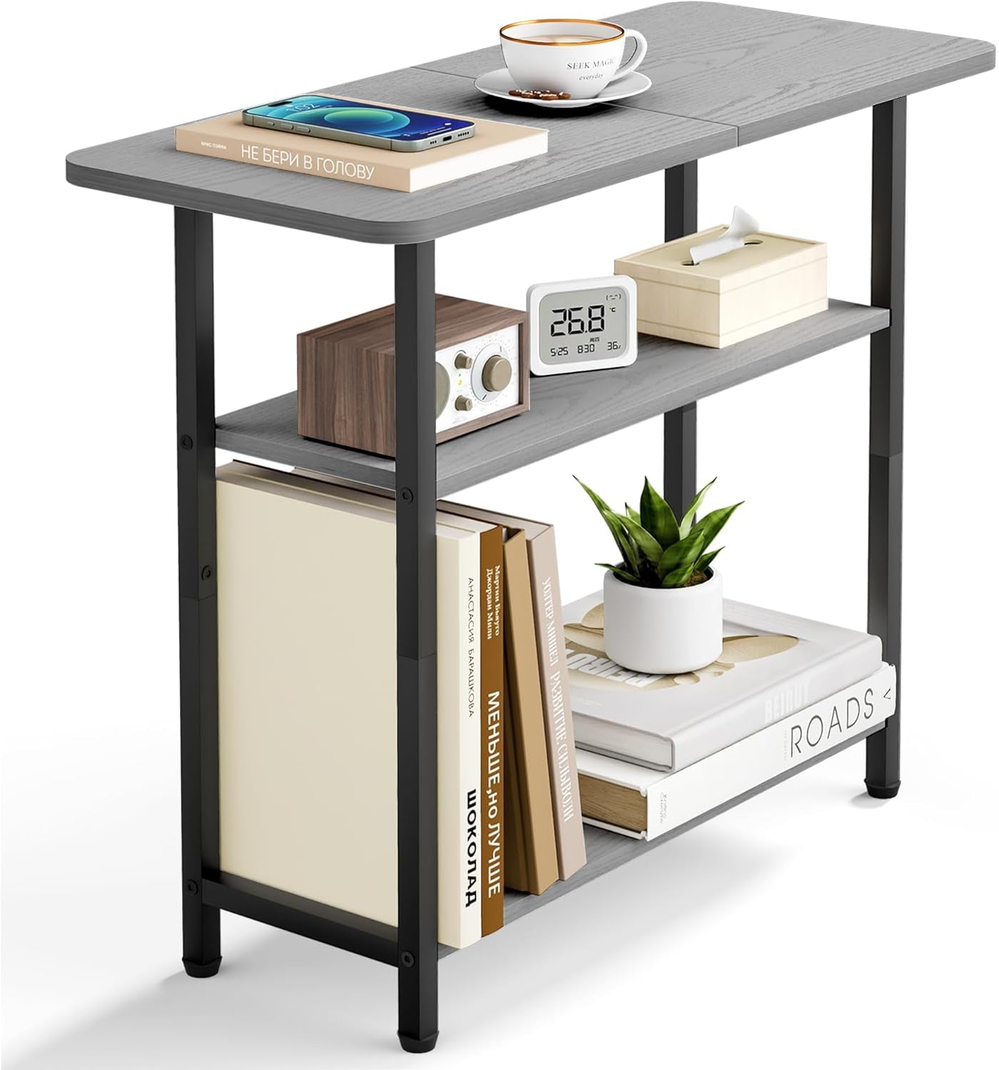 Gray three-tier side table staged with books, a small plant and tabletop cup on a white background.