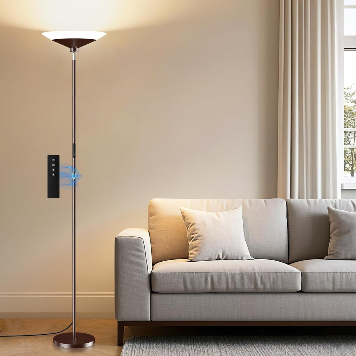 Warm uplight from the floor lamp illuminating the wall above a light-gray sofa with remote nearby.