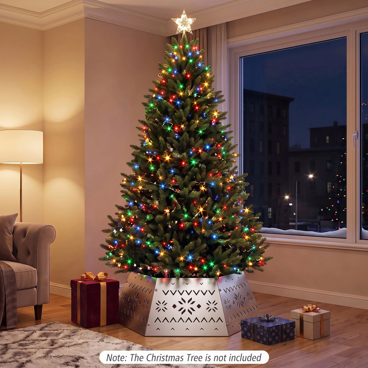 A lit Christmas tree stands in the silver cutout collar in a living room, with wrapped gifts nearby.