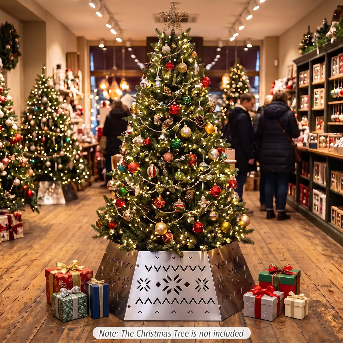 Lit Christmas tree in a silver patterned collar, surrounded by presents in a warmly lit shop.