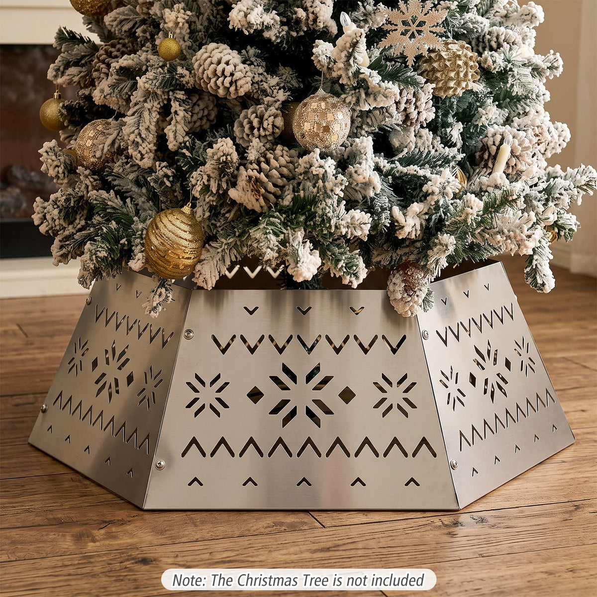 Close view of a silver tree collar with cutout patterns beneath snow-dusted branches.