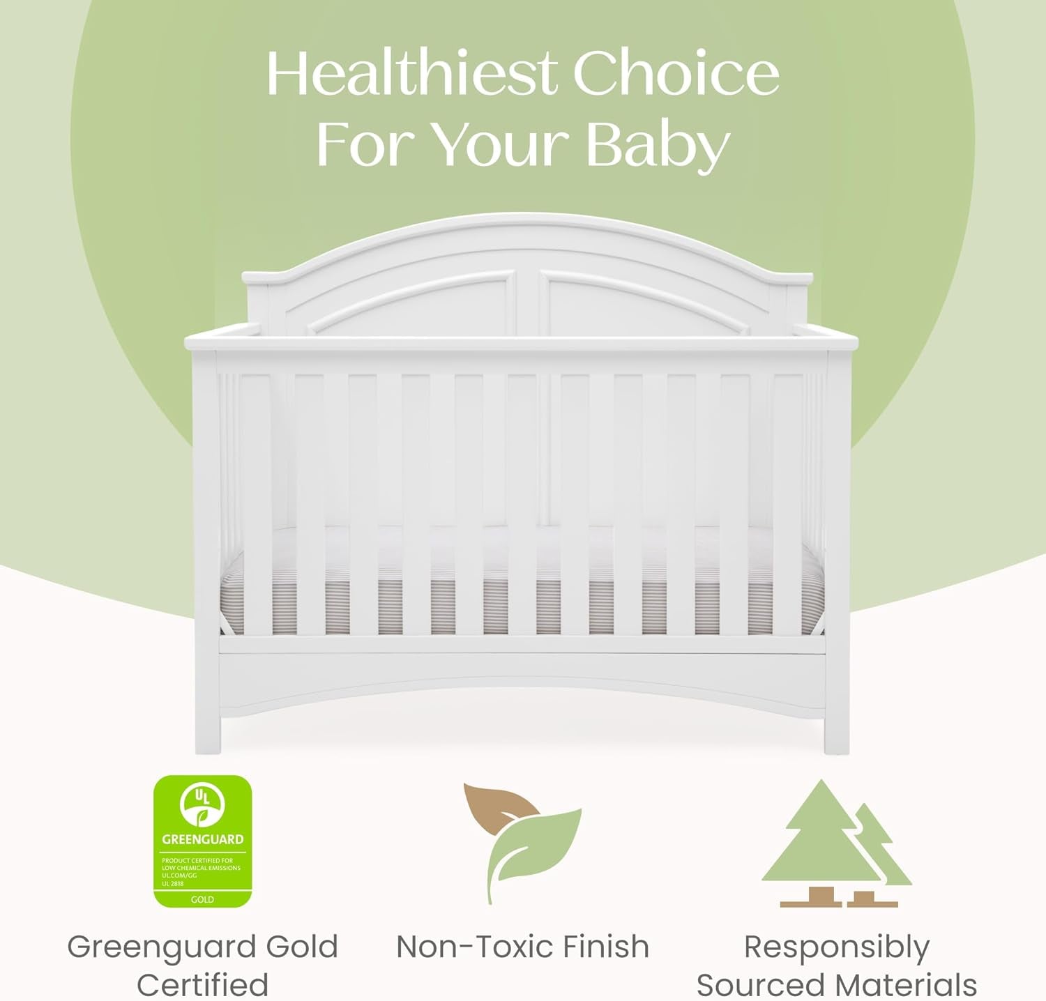 Front view of a white baby crib with arched bell-shaped headboard against a green background