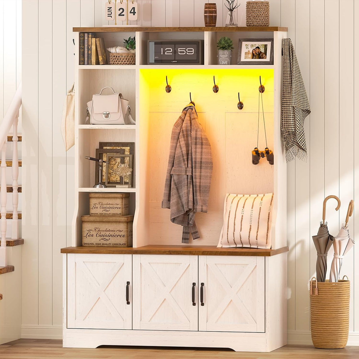 White entry hall tree staged with warm yellow RGB backlight, coat hanging and cubbies visible
