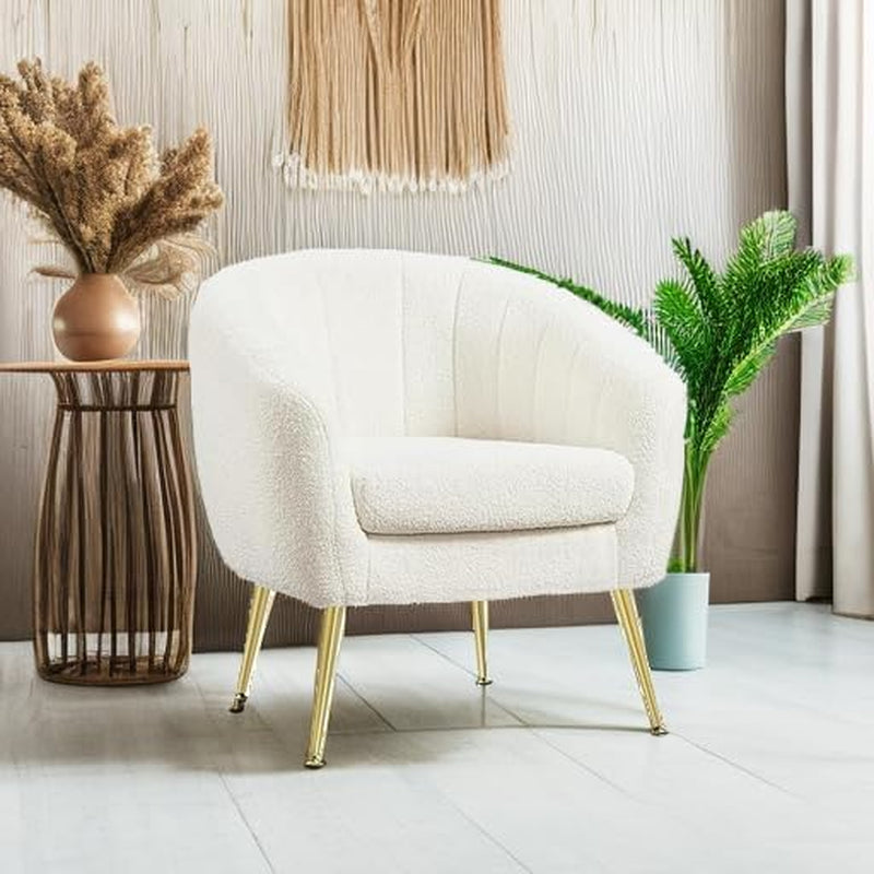 Ivory bouclé barrel chair staged beside a woven side table and plant on a light floor