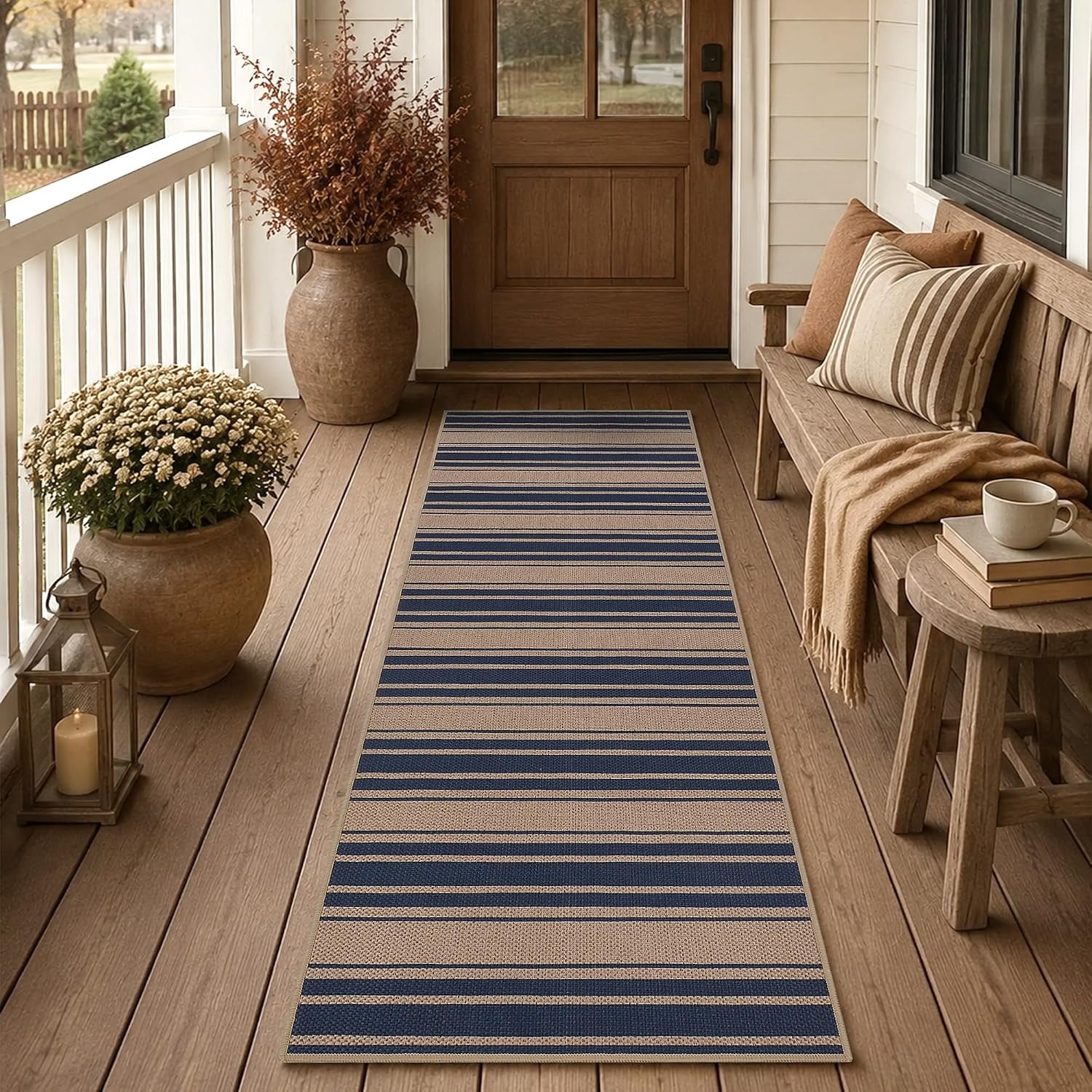 Long striped navy-and-beige runner on a wooden porch leading to a front door, bench at right.