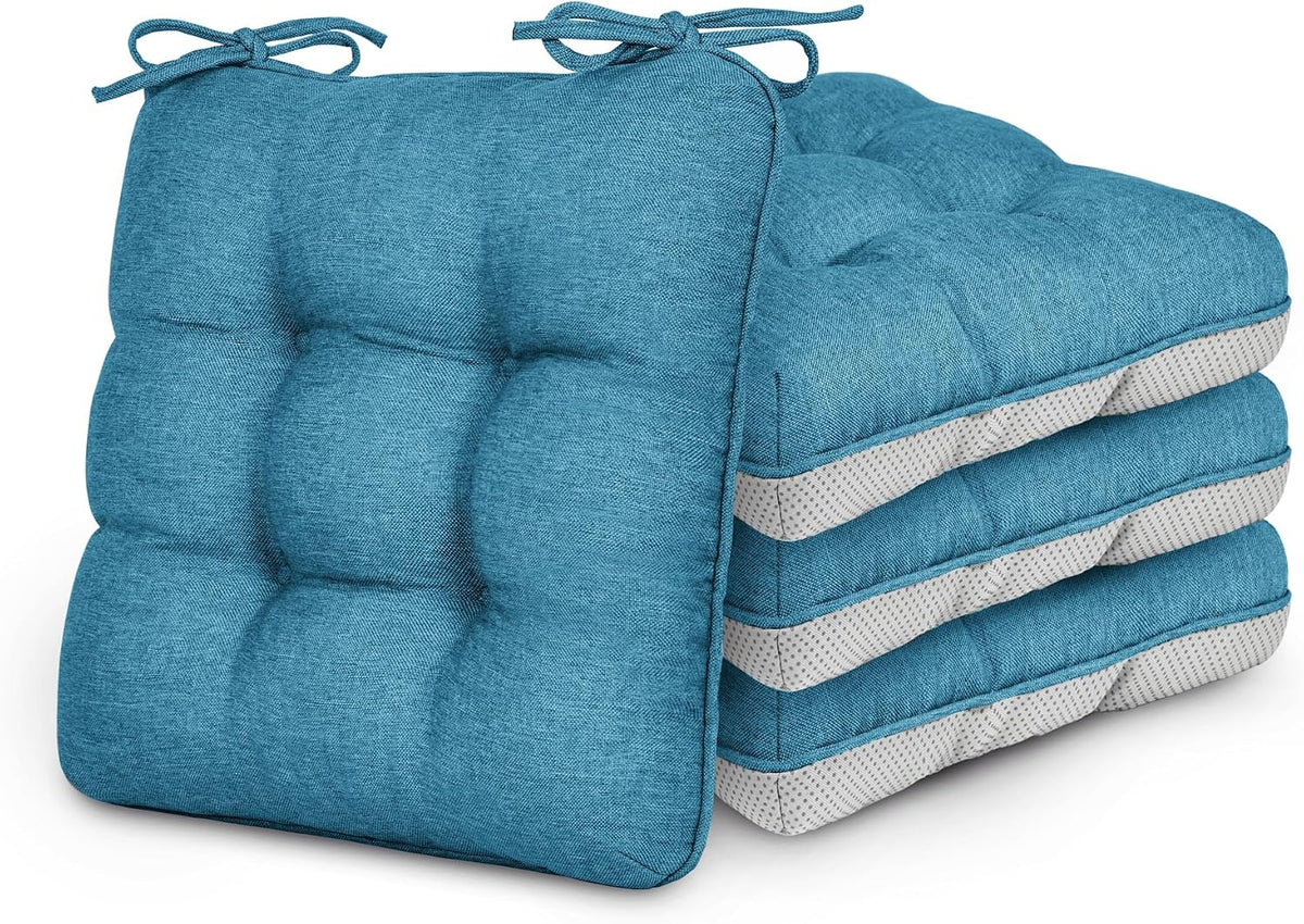 Stack of four aqua-blue tufted seat cushions with corner ties and dotted grey undersides.