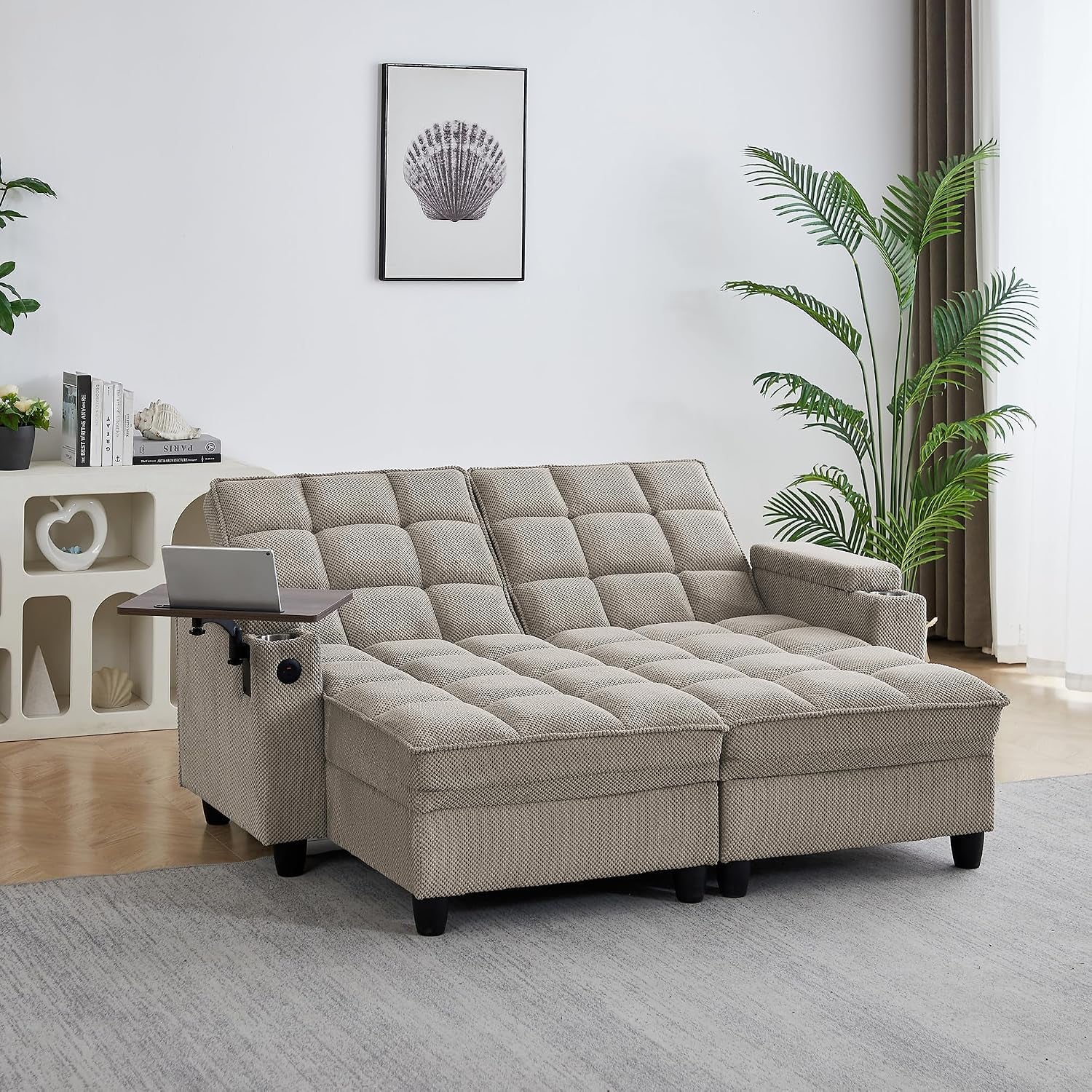 Beige tufted chaise lounge set up as a double seat with swivel tray extended in bright living room.