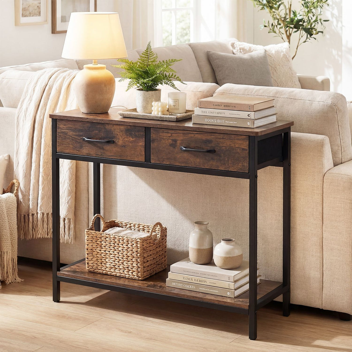 Dark console table with two drawers and a lower shelf styled beside a beige sofa.