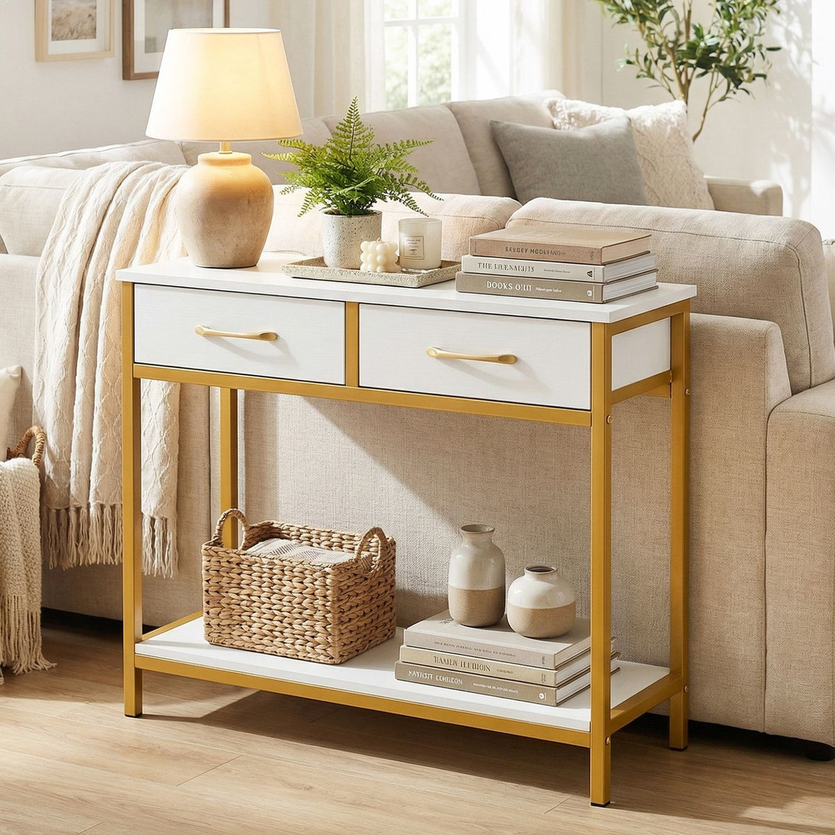 White console table with gold-tone frame styled behind a sofa in a living room