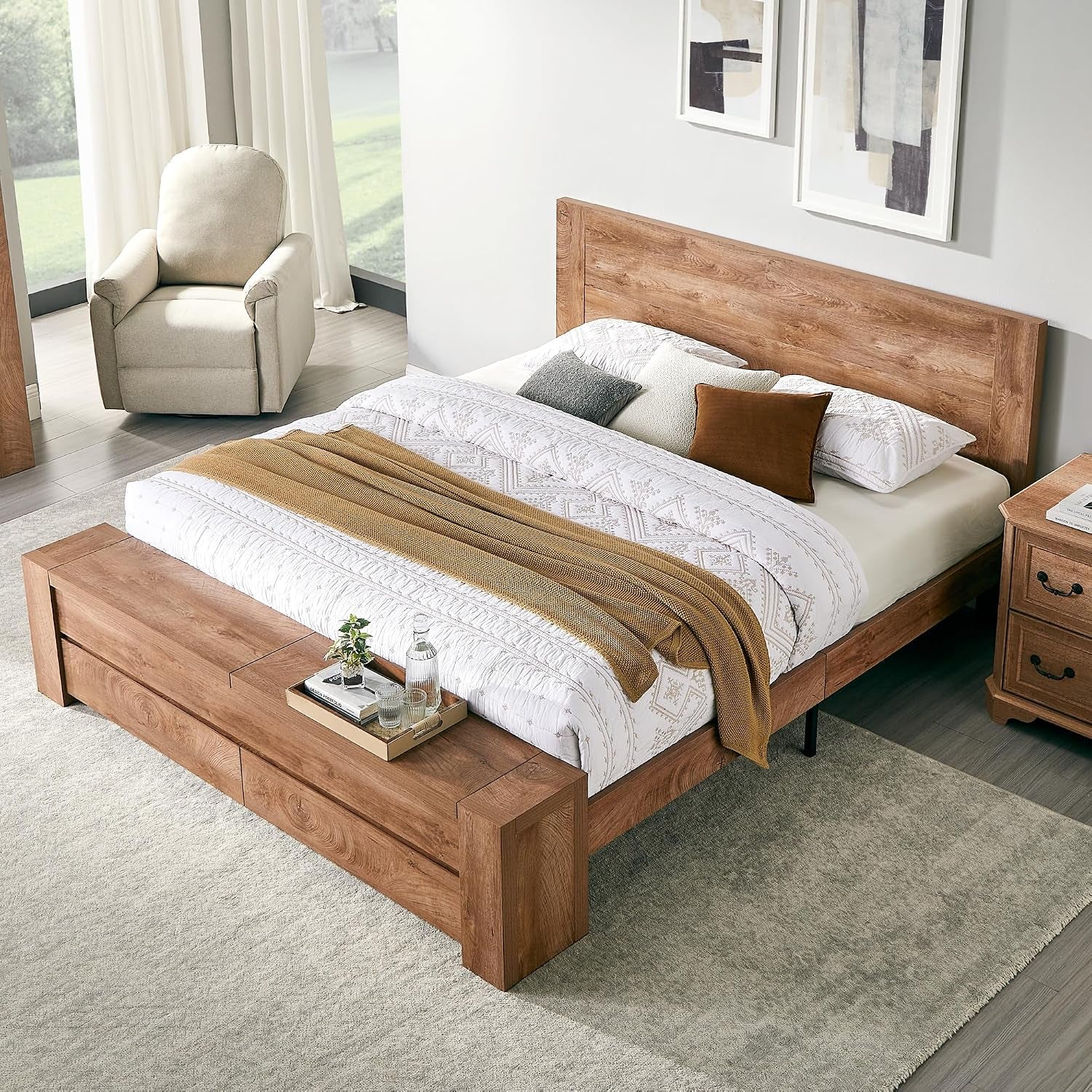 Light wood finish platform bed with matching wood storage bench and neutral bedding in a bright room.