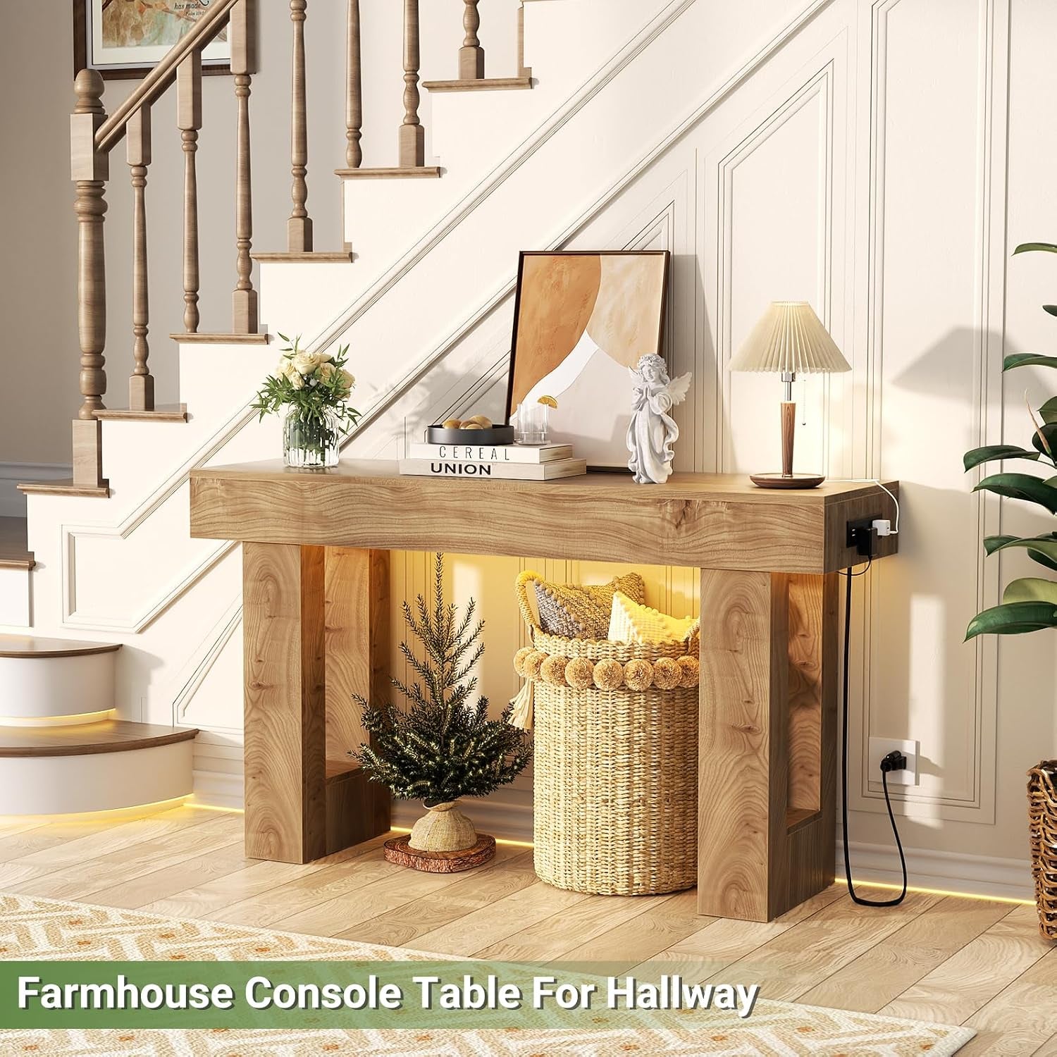 Natural oak console table styled under stairs with a woven basket and warm backlighting visible beneath the top