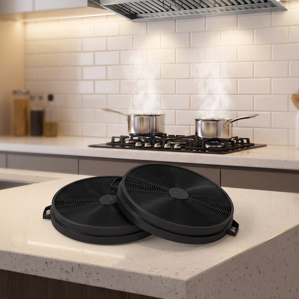Two black round range hood filters rest on a countertop beneath a stove and hood.