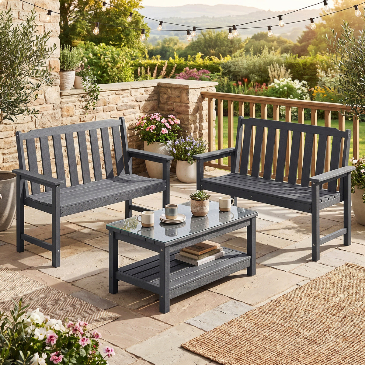 Two charcoal slatted benches sit around a low coffee table on a garden patio.