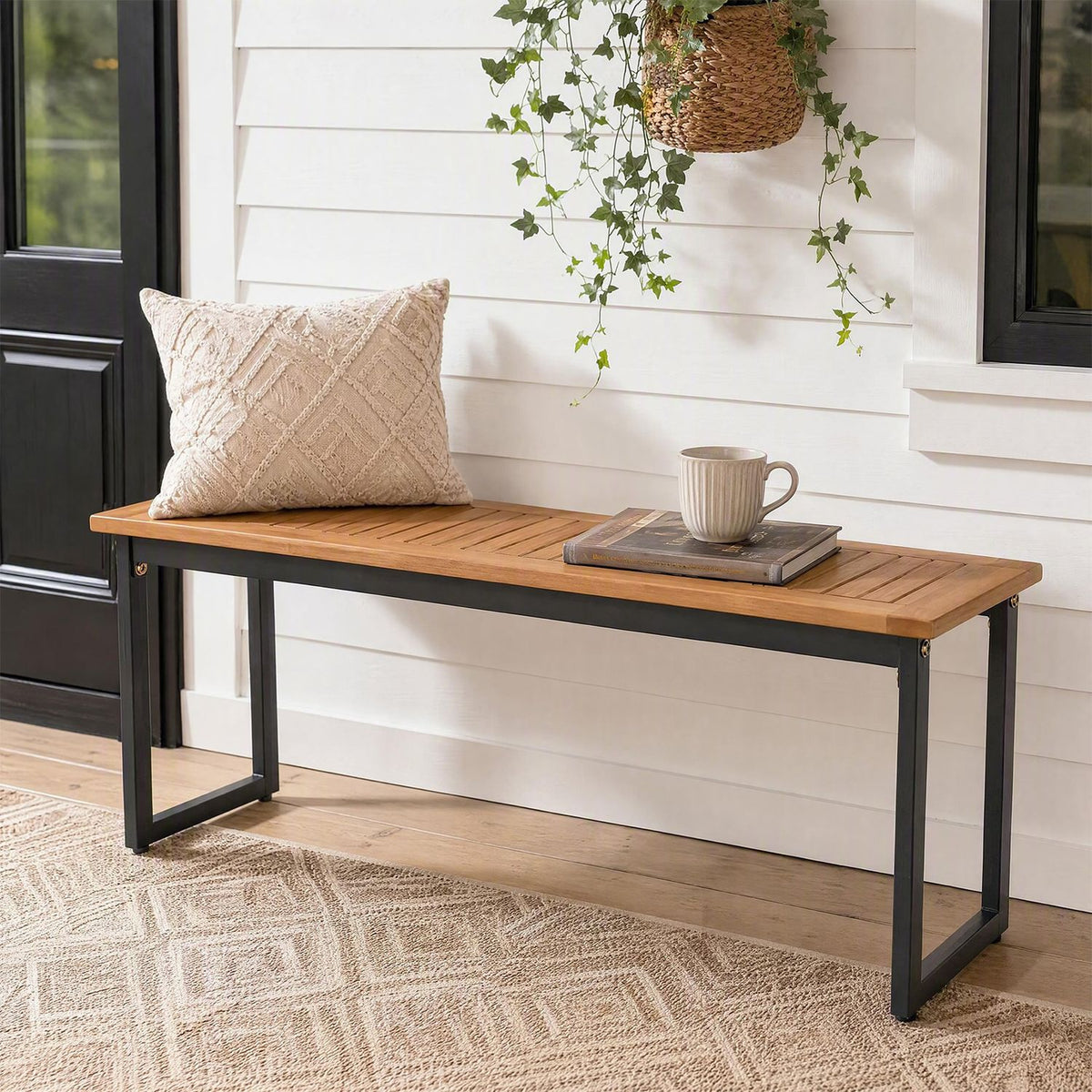 Wooden slat bench with black metal legs styled against a white paneled wall.
