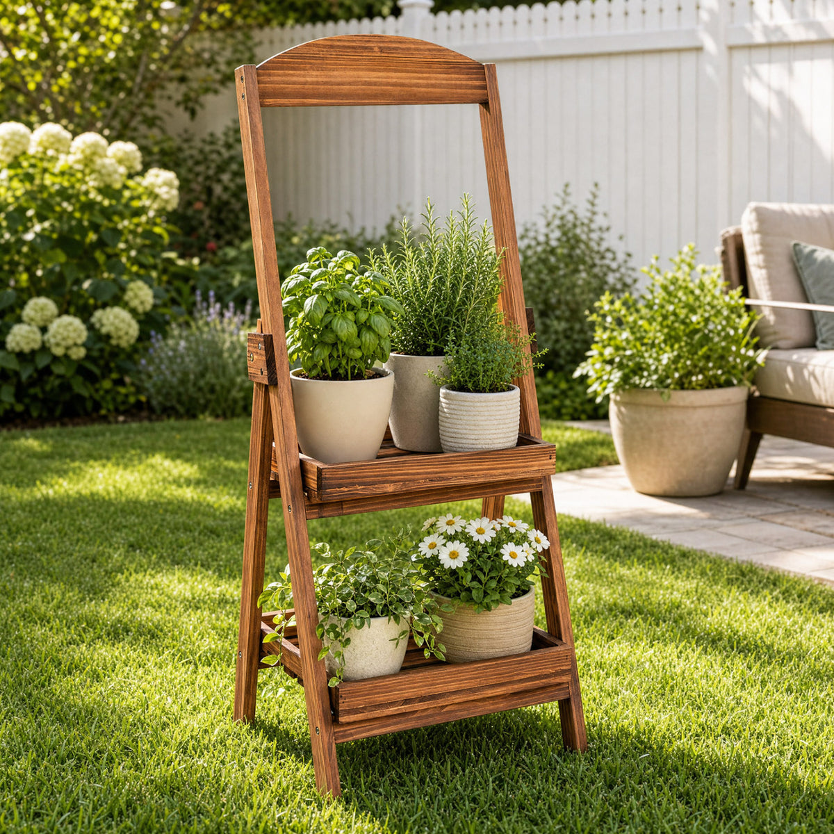 Wooden ladder shelf filled with potted herbs and flowers on a lawn beside a patio.