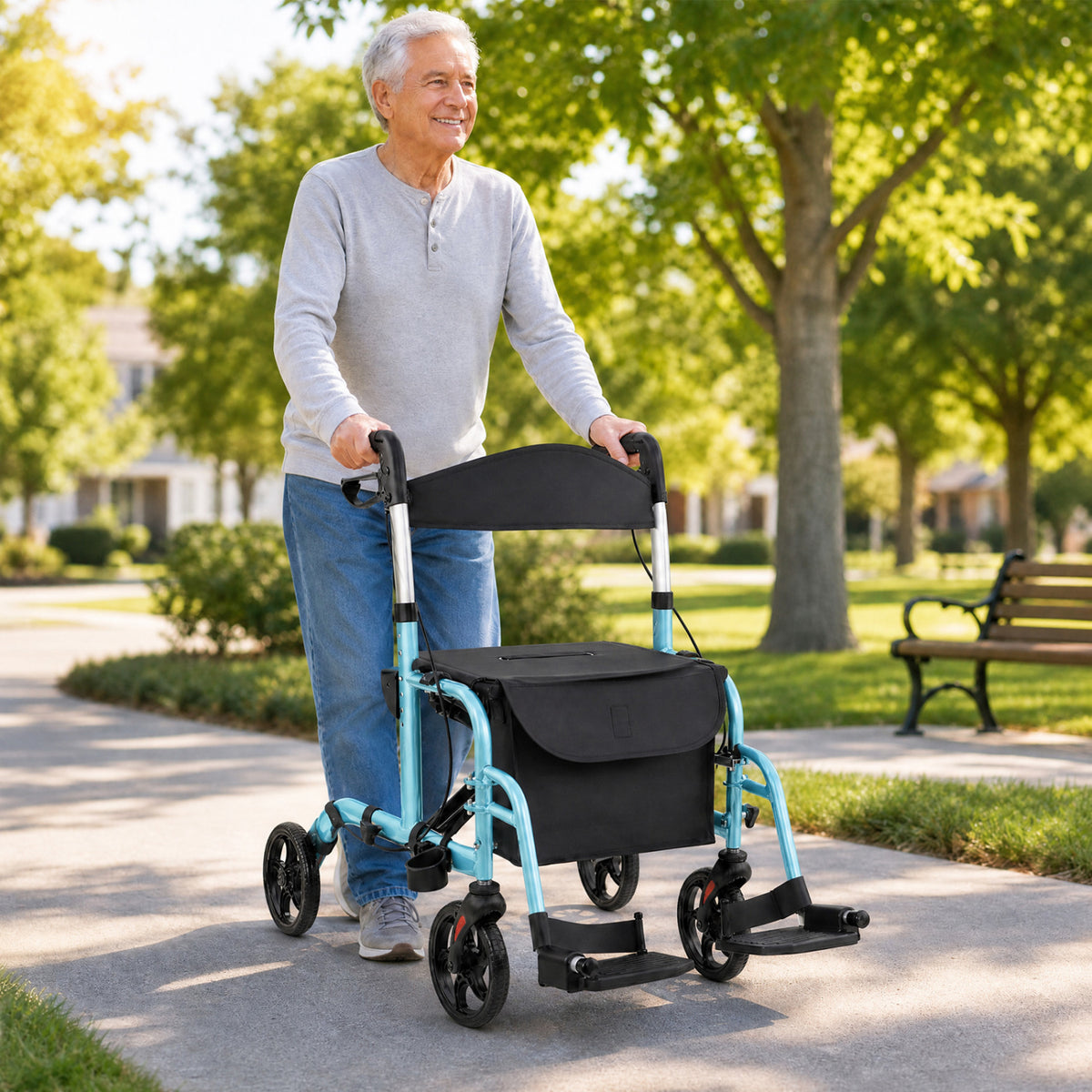 An older man pushes a turquoise rollator with a black seat and storage bag along a sunny park path.