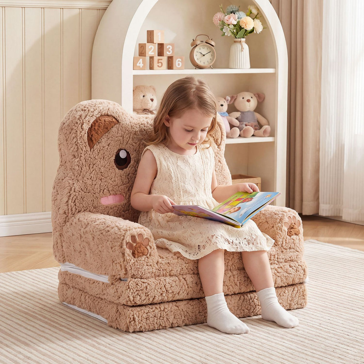 A child reads in a plush bear-shaped sofa with rounded arms and a tall character back.