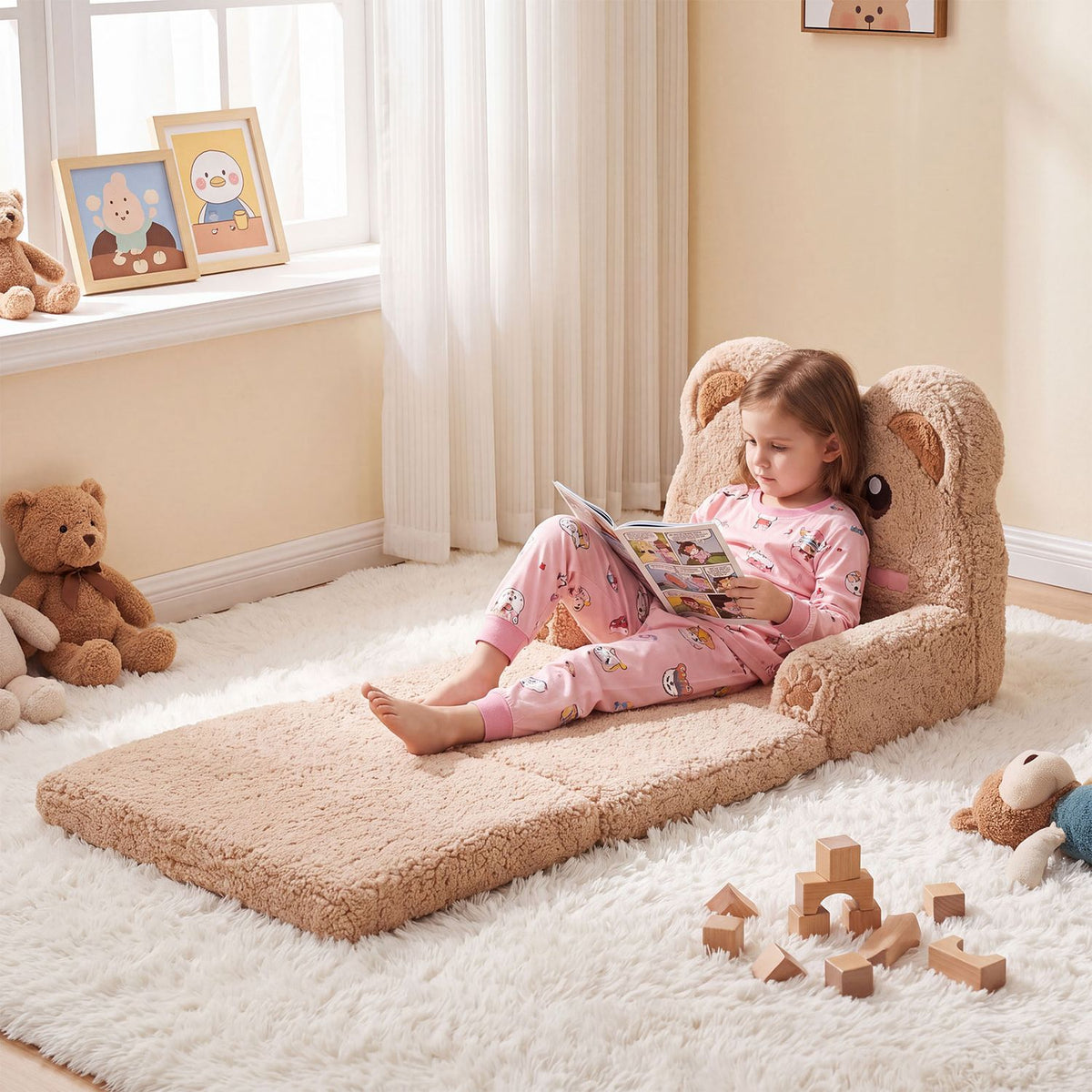 A child lounges with a book on the extended bear sofa bed in a bright playroom.