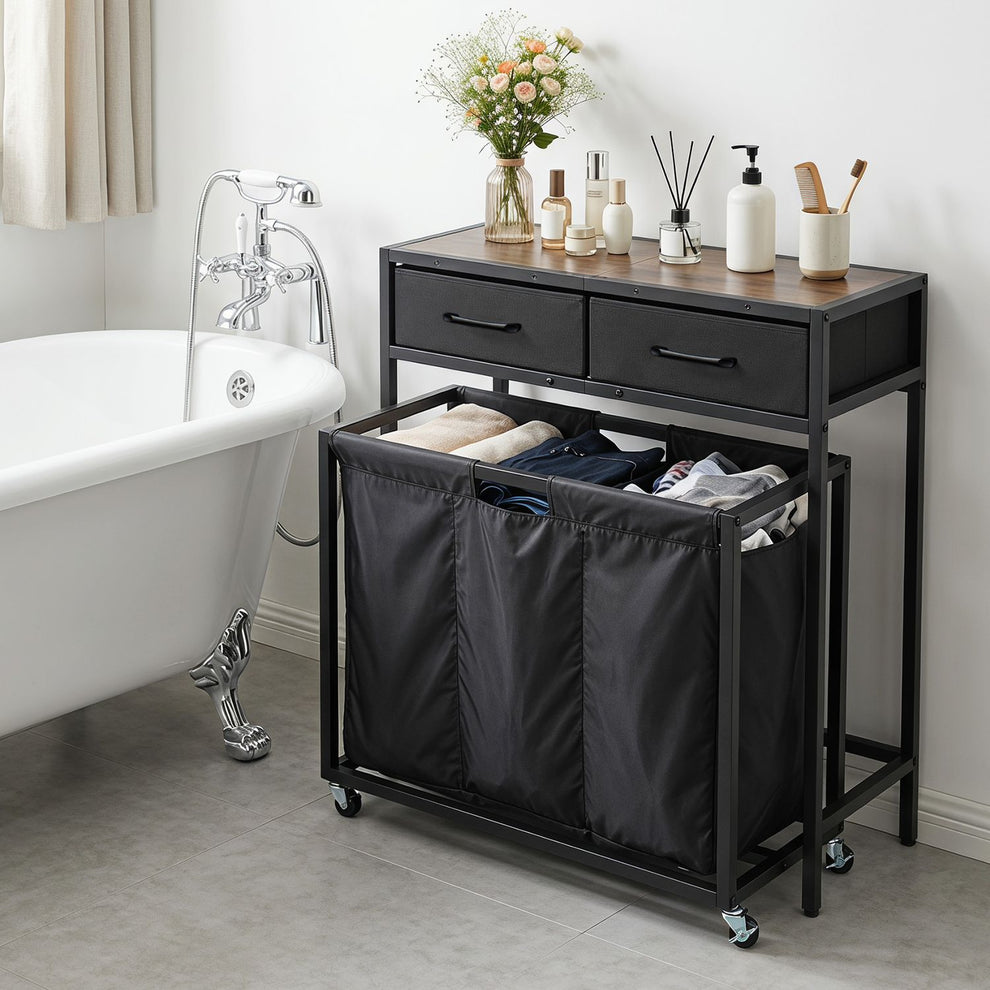 Black laundry sorter console beside a bathtub, with three open fabric sections and two drawers.