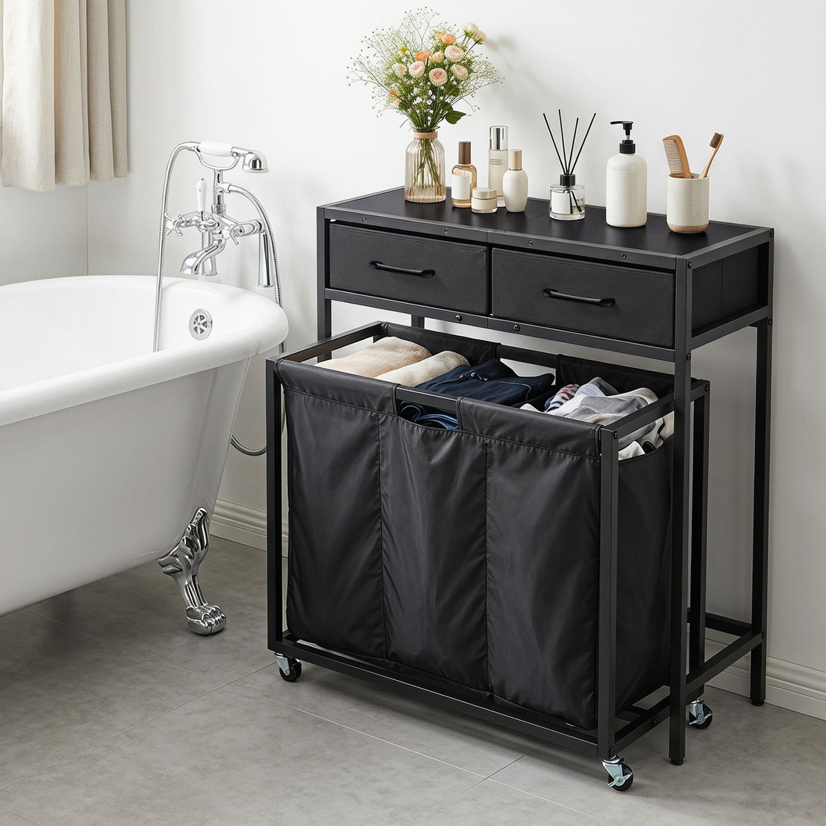 Black laundry sorter beside a bathtub, with three open fabric compartments holding clothes and two drawers above.