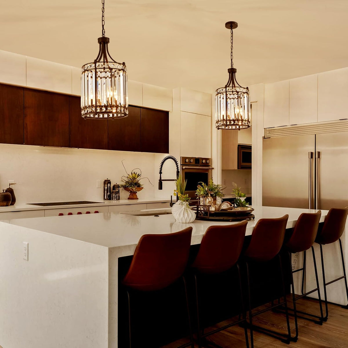 Pair of black crystal pendant chandeliers hung over a kitchen island with warm ambient light