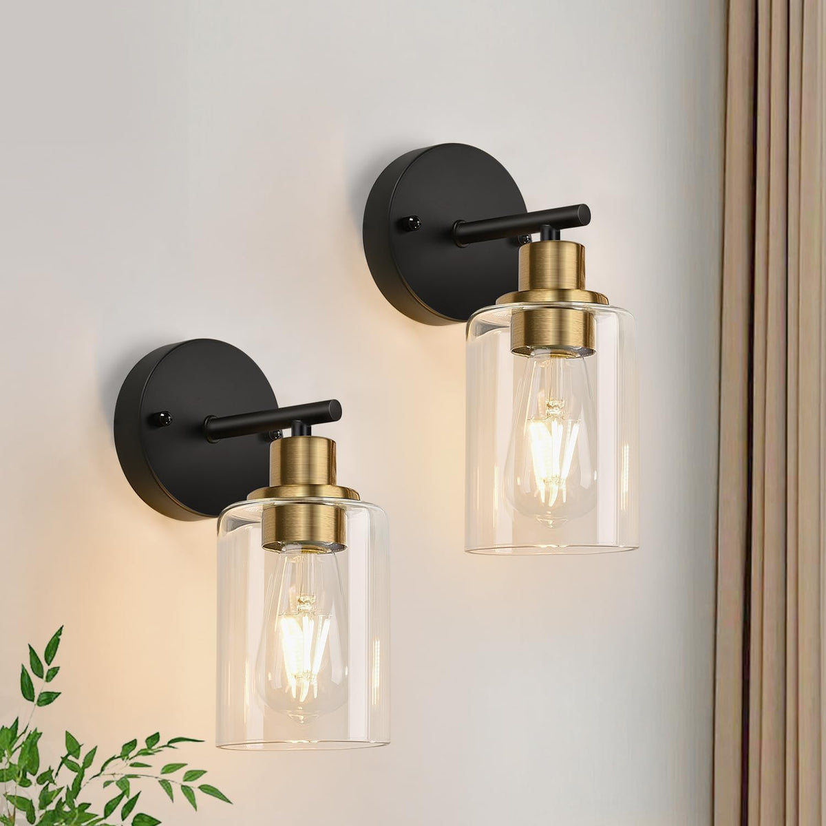 Two black wall mounts with clear glass shades and brass-colored hardware accents.