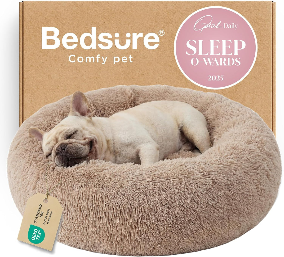 Round tan faux-fur donut bed with a sleeping French bulldog in front of cardboard packaging