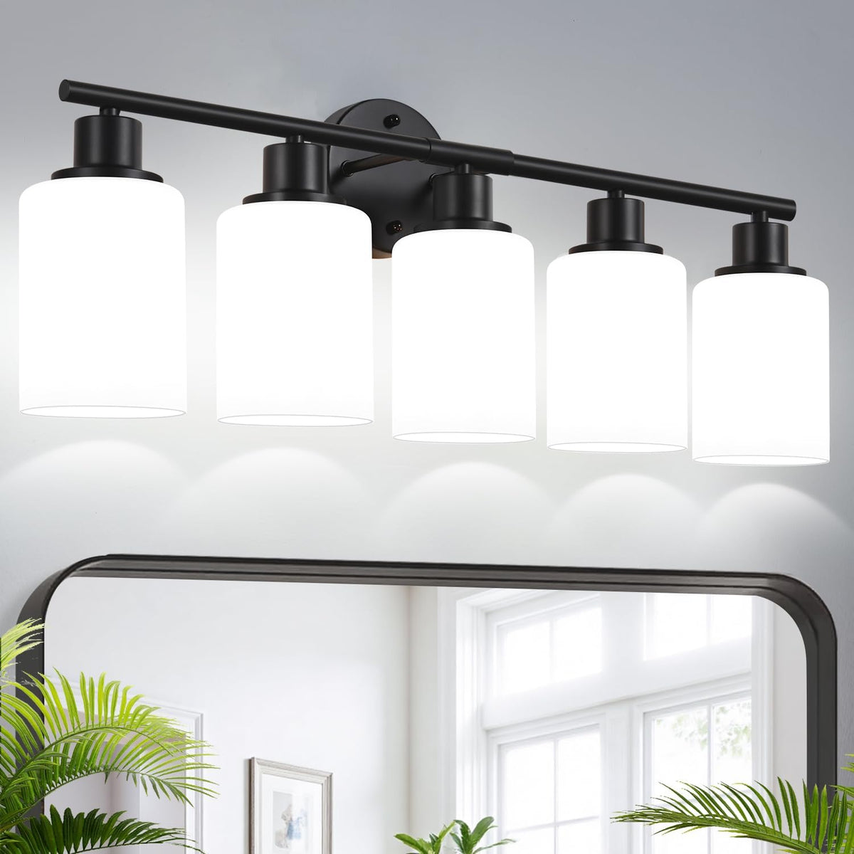 Black five-light vanity fixture shown lit, with frosted-looking cylindrical shades over a mirror.