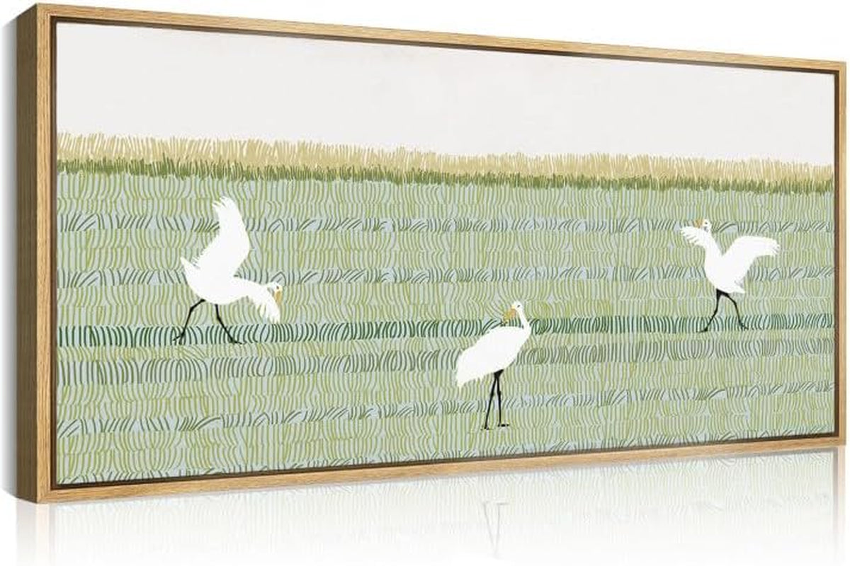 Horizontal framed artwork showing a green patterned field with three white wading birds, reflected below.