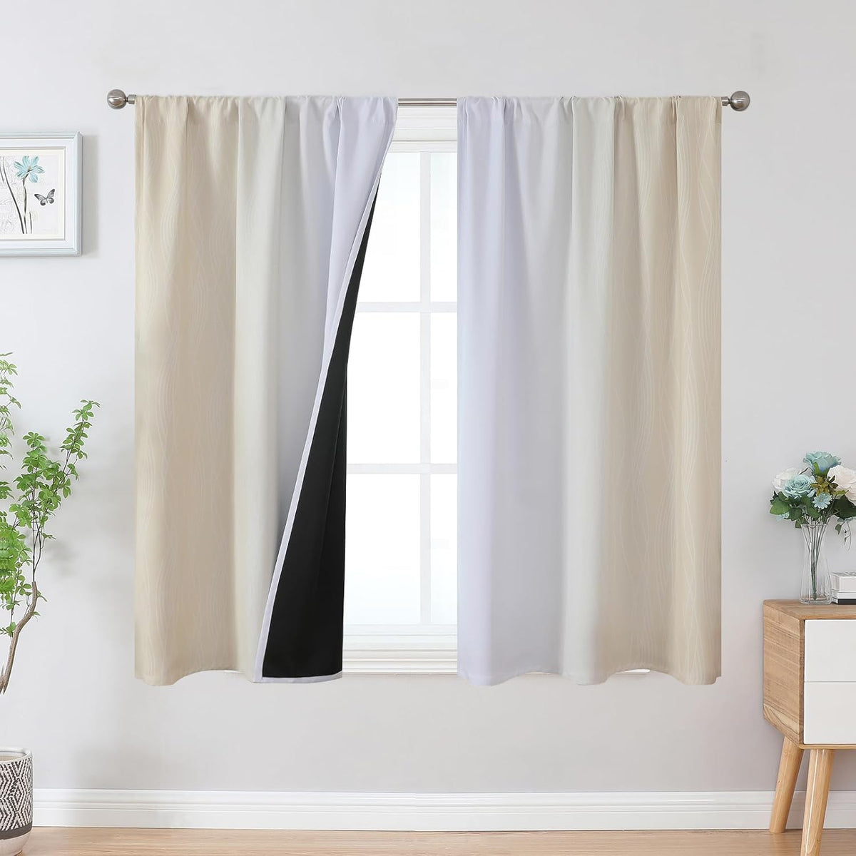 Window with beige-to-white ombre curtains hung on a metal rod, a panel opened to expose black backing.