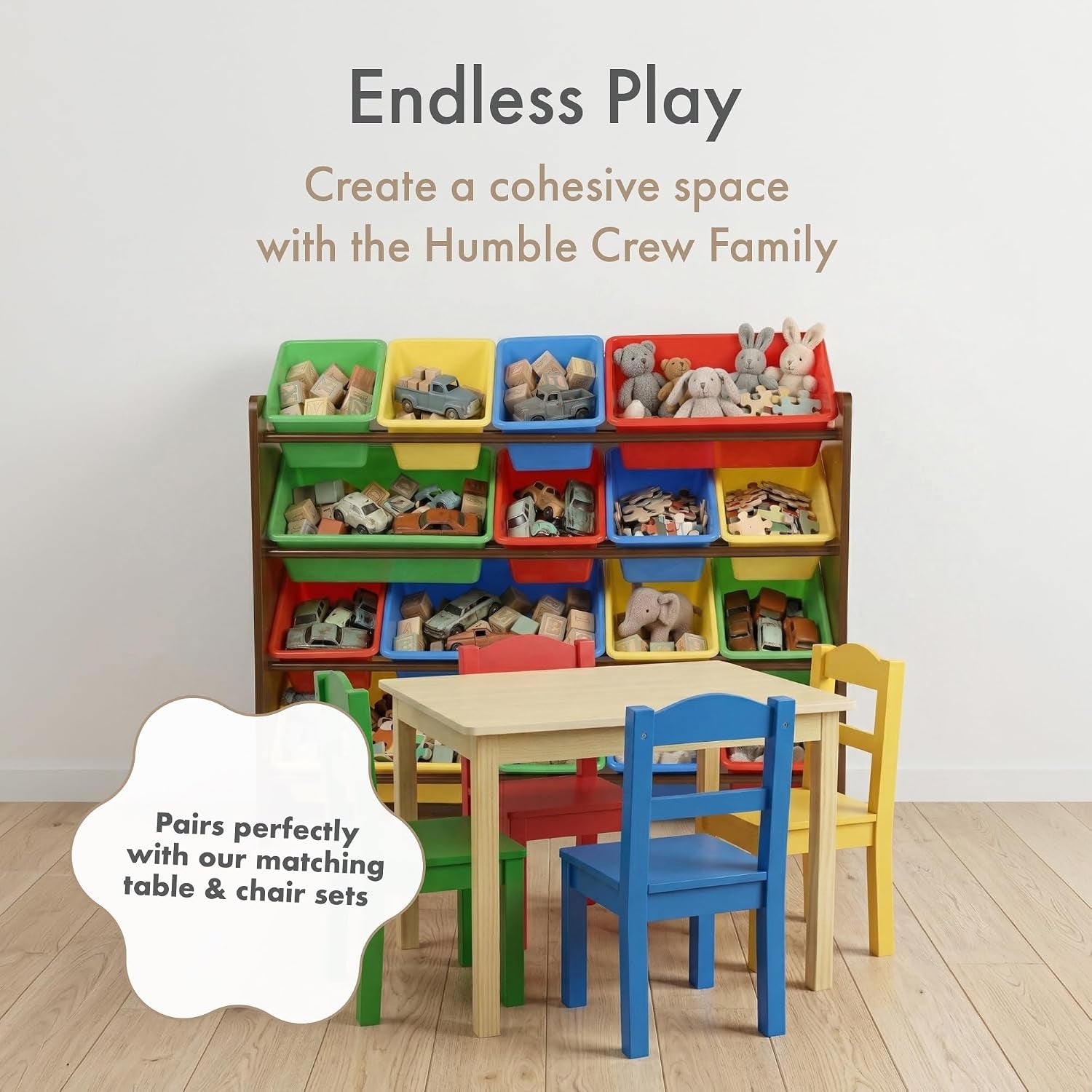 Playroom scene with a four-tier toy organizer of 16 colorful bins behind a small table and four bright chairs.