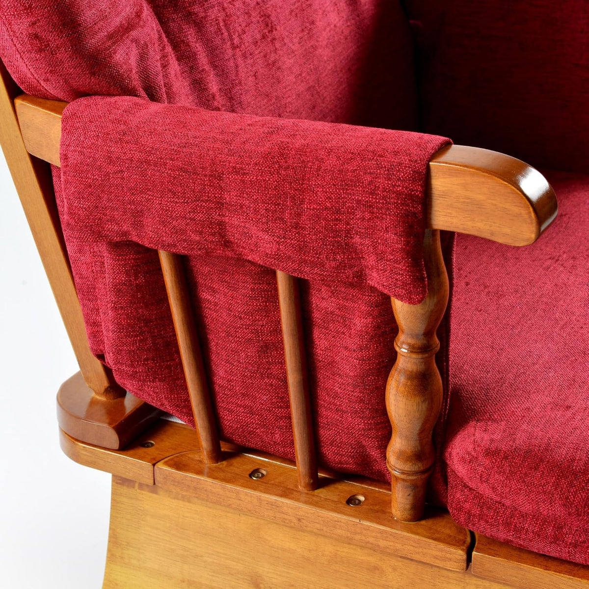 Close-up of the chair's oak armrest, turned spindle and red fabric arm cover.