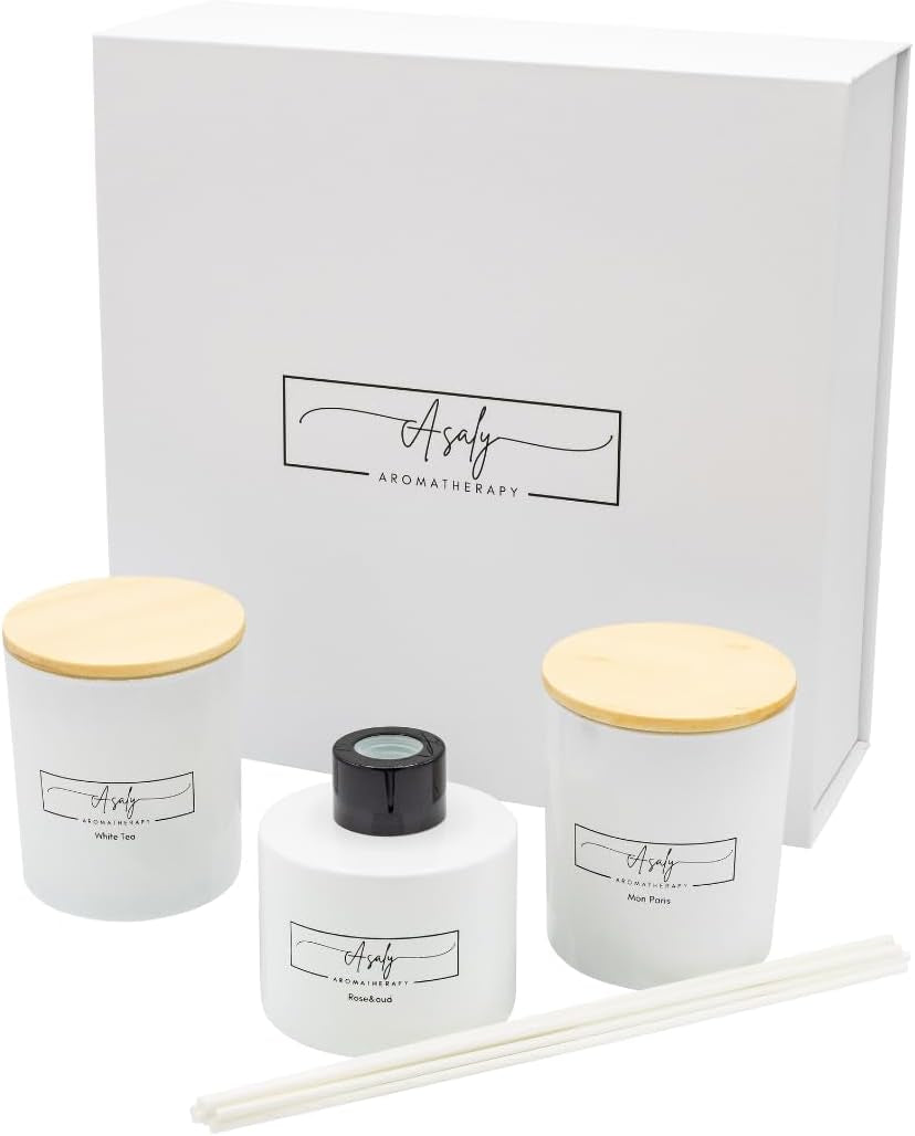 White presentation gift box with two white glass candles with wooden lids, round diffuser bottle and unplaced reeds in front.
